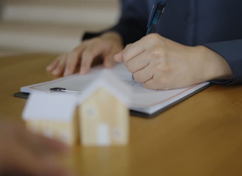 osoba potpisuje ugovor za iznajmljivanje stana