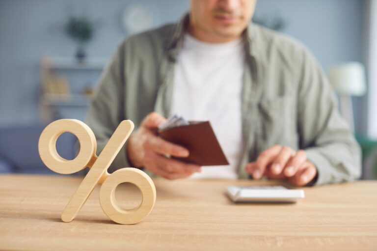 Osoba računa troškove kredita uz simbol procenta koji predstavlja kamatu